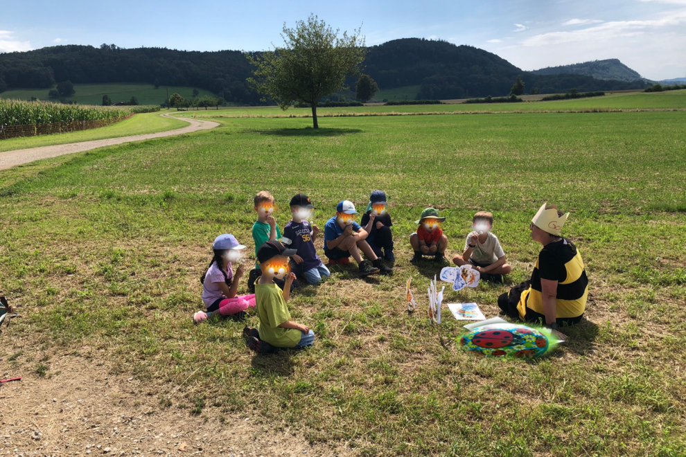 bedeckte kindergesichter am Boden sitzend